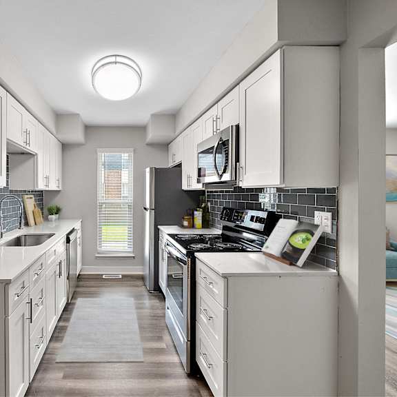 a modern kitchen with white cabinets and appliances.