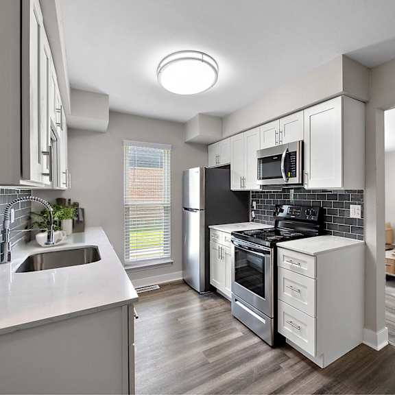 a modern kitchen with a refrigerator, sink, and stove.
