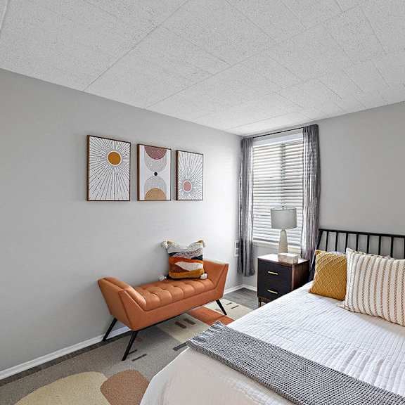 a bedroom with a bed, a chair, and a nightstand.