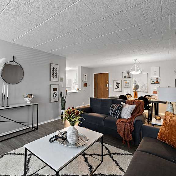 a living room with a black couch and a white coffee table.