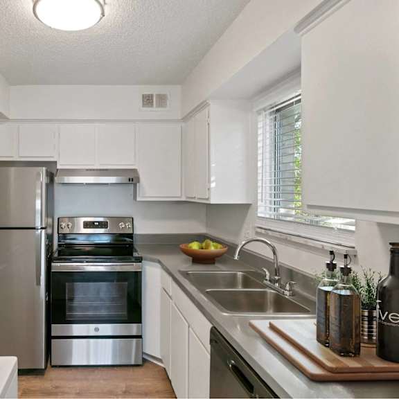 a modern kitchen with stainless steel appliances and white cabinets.