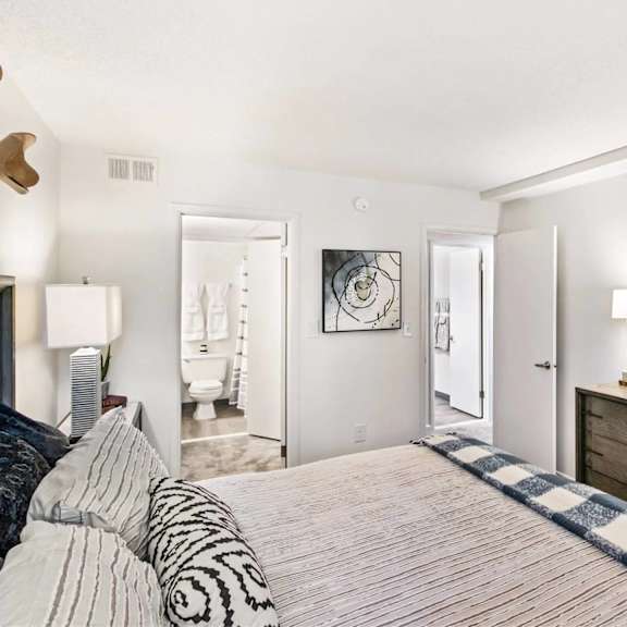 a bedroom with a bed, dresser, and mirror.