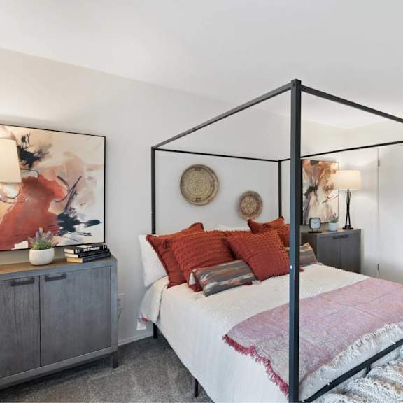 a bedroom with a four poster bed and a grey cabinet.