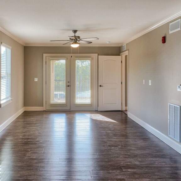 Thumbnail 3 of 5 A room with a ceiling fan and sliding glass doors at Mode at Melbourne, LLC Apartments, Florida, 32901