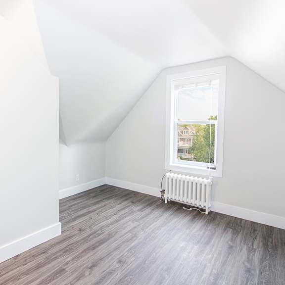 a bedroom with hardwood floors and a white door