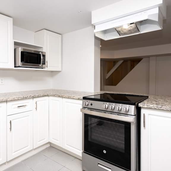 a kitchen with white cabinets and a black stove top oven.