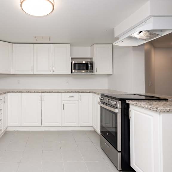 a kitchen with white cabinets and black appliances.