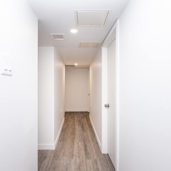 a long hallway with a door at the end.
