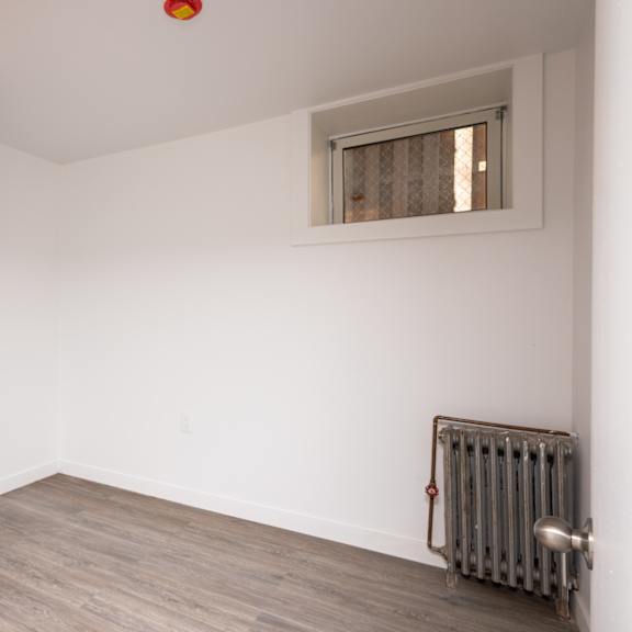 a room with a window and a radiator on the wall.