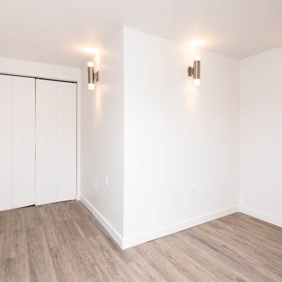 a room with a white door and two lights on the wall.