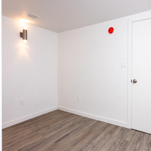 a white door is in a room with a red dot on the wall.