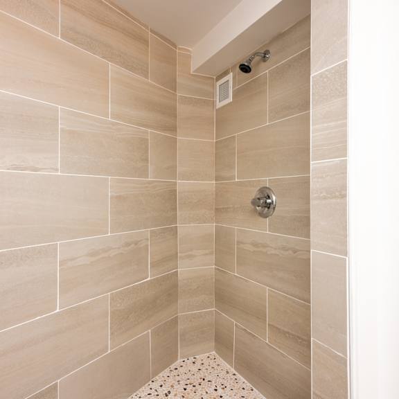 a shower area with a tiled wall and floor.