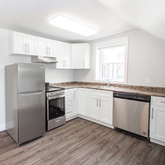 a kitchen with white cabinets and stainless steel appliances
