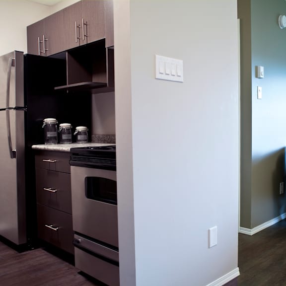 a kitchen with a refrigerator, oven, and cabinets.