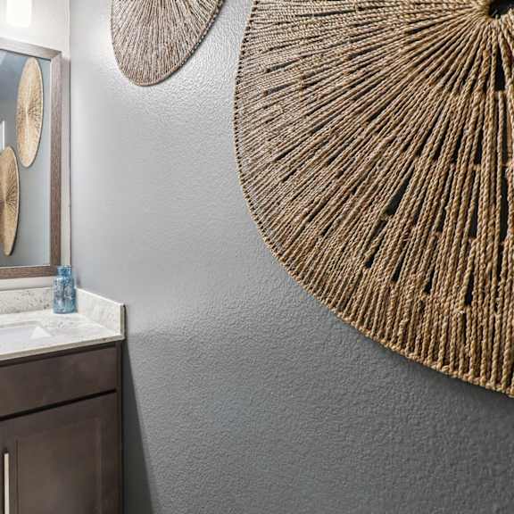 a bathroom with a sink, mirror, and a large fan.