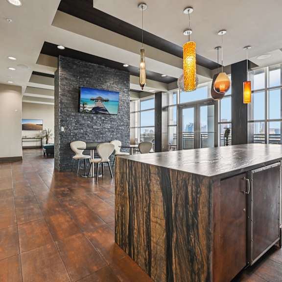 a modern bar area with a stone wall and wooden bar.