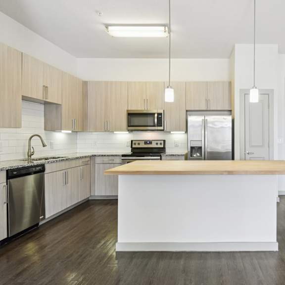 a kitchen with a white island and wooden cabinets.
