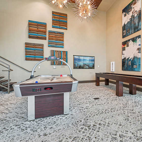 a pool table in a room with a carpeted floor and a staircase.