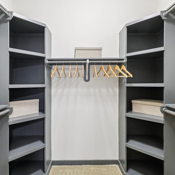 a grey shelving unit with a white cloth hanging on the middle shelf.