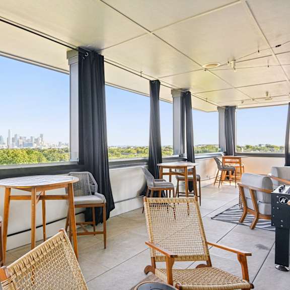 a balcony with a table and chairs overlooking a cityscape.