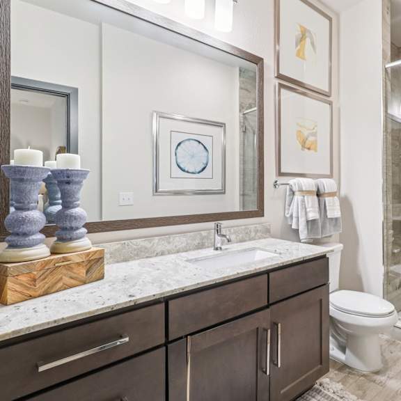 a bathroom with a toilet, sink, and shower.