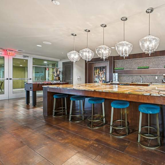 a bar with blue stools and a wooden counter.
