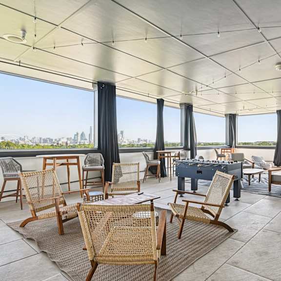 a patio with a table and chairs overlooking a city.