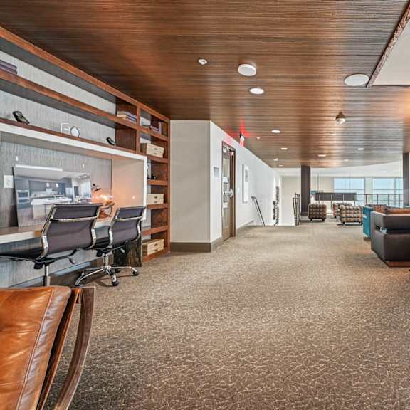 a modern office space with a long carpeted hallway and a variety of seating options.