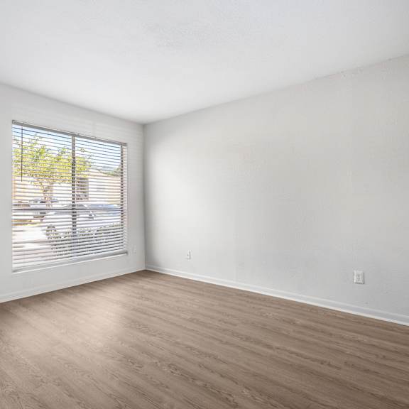 a room with a window and wooden flooring.