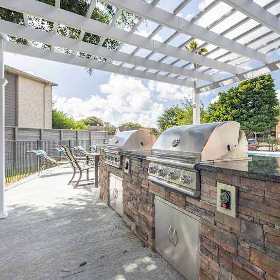 an outdoor kitchen area with a grill and sink.