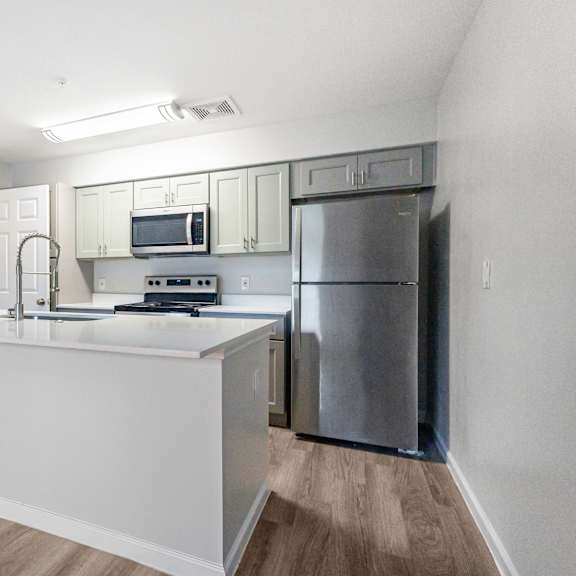 a kitchen with a white counter and stainless steel appliances.