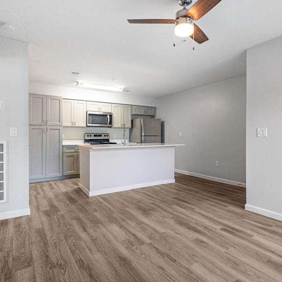 a kitchen with a white island and wooden floors.