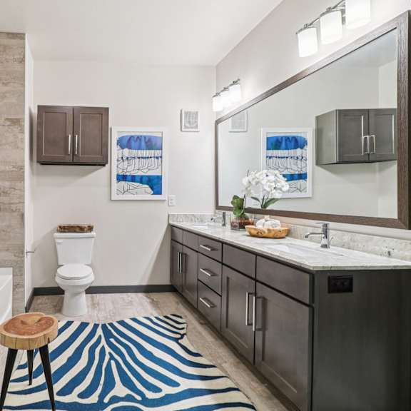 a bathroom with a toilet, sink, and a glass shower stall.