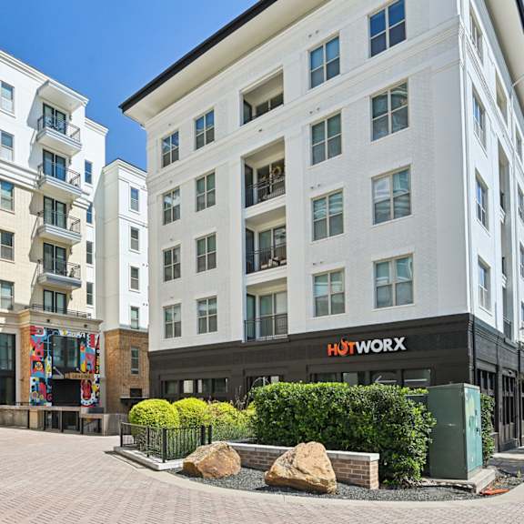 a large rock sits in the middle of a courtyard between two buildings.