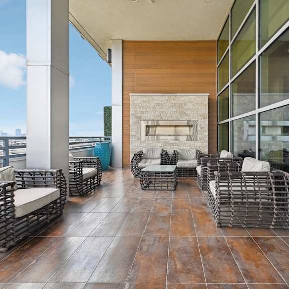 a patio with a fireplace and chairs.
