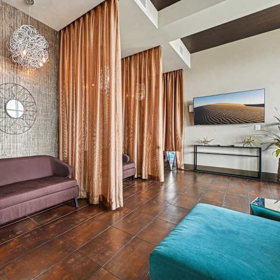 a living room with a purple couch and a blue ottoman.