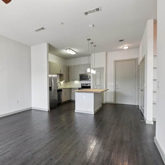 a kitchen area with a refrigerator, oven, and sink.