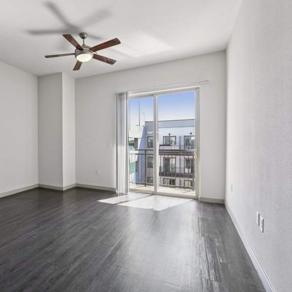 a room with a ceiling fan and a view of the outside.