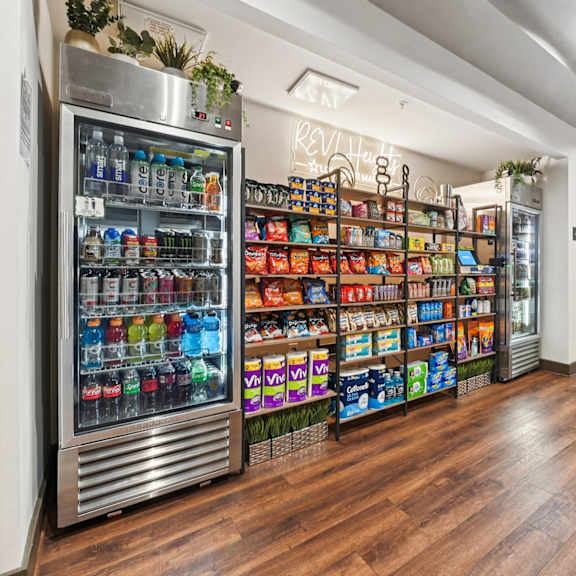 a well-lit room with a large refrigerator and a wooden floor.