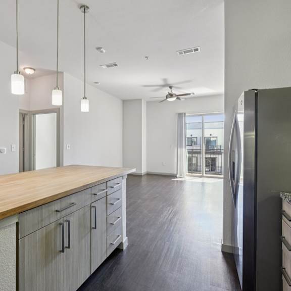 a kitchen with a wooden counter top and white cabinets.