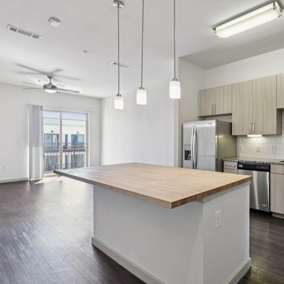a kitchen with a wooden counter top and white cabinets.