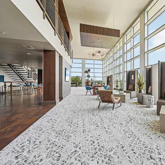 a large, modern living room with a staircase and a view of the city.