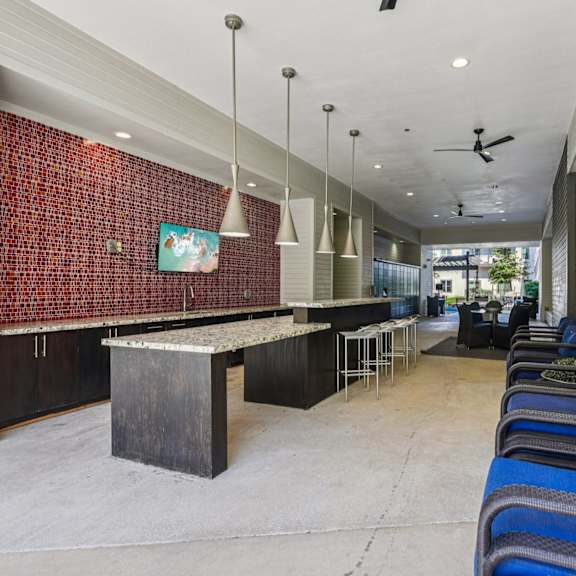 a room with a red brick wall and a long row of blue chairs.