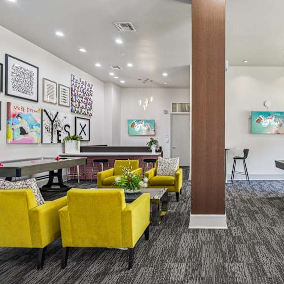 a room with a pool table and a bar area.