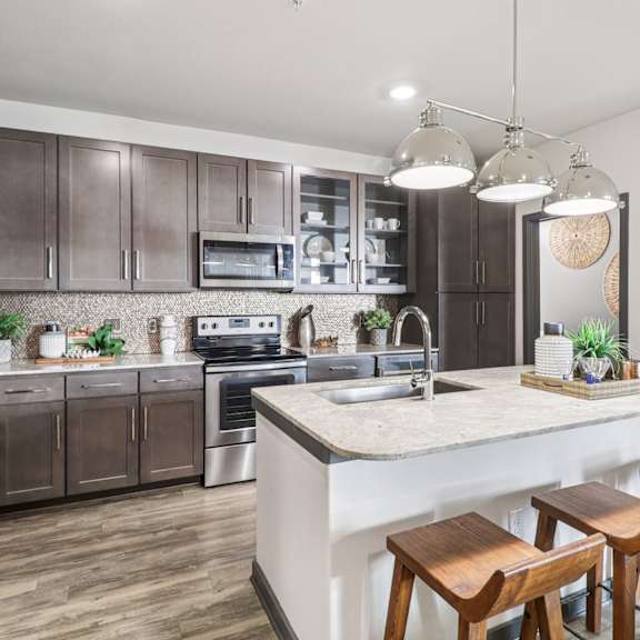 a modern kitchen with a large island and wooden stools.