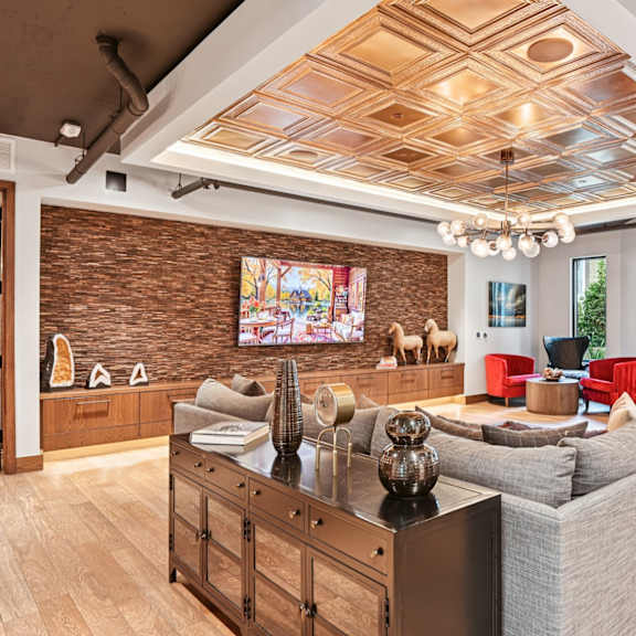 a living room with a grey couch and a brown wooden cabinet.