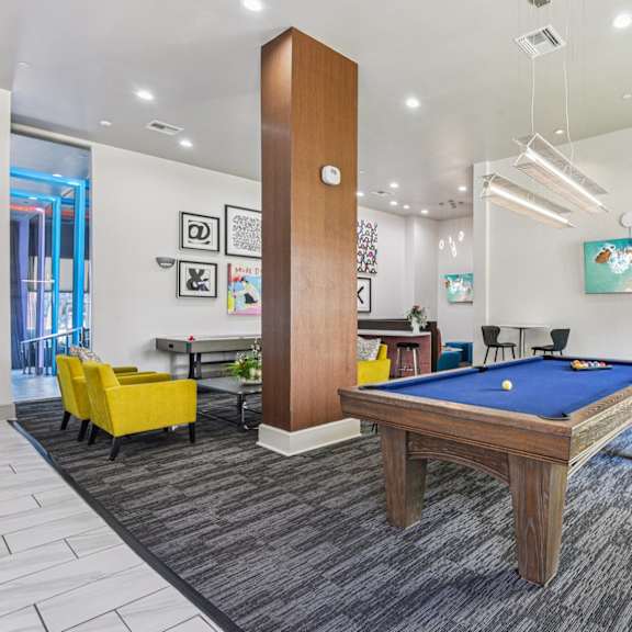 a room with a pool table and a tall wooden column.