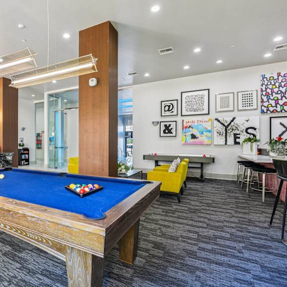a pool table is in the middle of a room with a blue carpet.