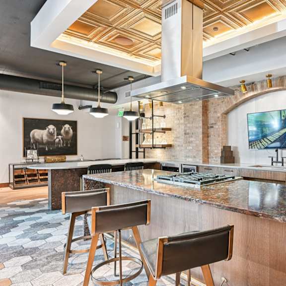 a modern kitchen with a large island and a brick wall.