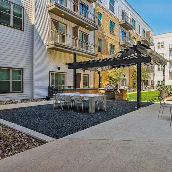 a patio with a table and chairs under a pergola.